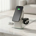 Multi-device charging station with smartphone, smartwatch, and wireless earbuds on a marble surface.